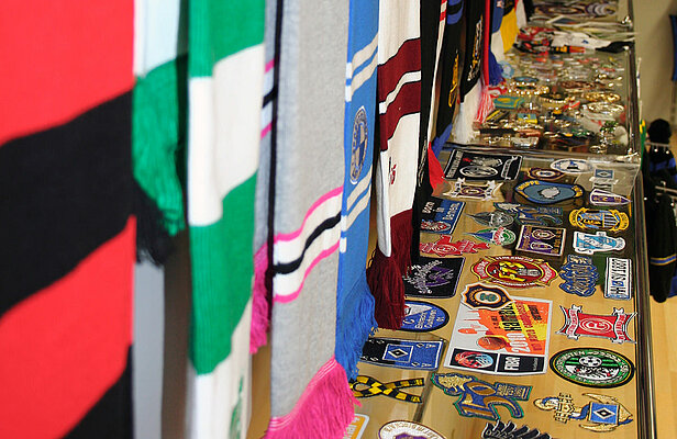 Eine Sammlung von Schals und Abzeichen, die auf einem Tisch ausgestellt sind.