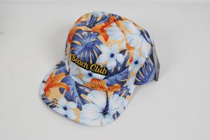 Baseballcap mit buntem Blumenmuster und dem Schriftzug 'Beach Club' auf der Vorderseite.