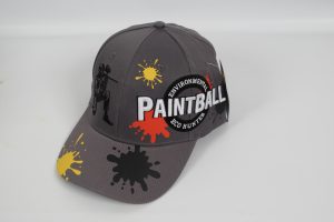 Graue Baseballcap mit dem Schriftzug 'PAINTBALL' und bunten Farbspritzern auf der Vorderseite.