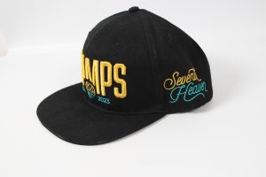 Schwarze Snapback-Basecap mit goldenen Buchstaben und buntem Stickdesign.