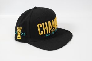 Schwarze Baseballmütze mit dem Schriftzug 'CHAMPIONS' und einem gelben Pokal-Design.