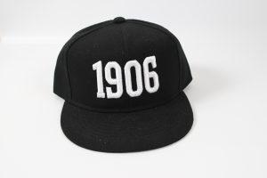 Schwarze Baseballkappe mit weißer Stickerei der Zahl 1906 auf der Vorderseite.
