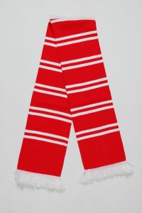Blockstreifenschal in Rot mit weißen Streifen und Fransen am Ende.