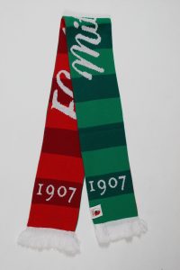 Blockstreifenschal in Rot und Grün mit dem Jahr 1907 und Fransen am Ende.