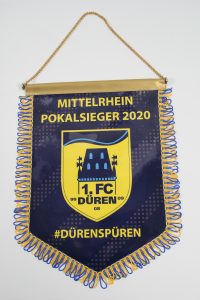 Wimpel des 1. FC Düren, der den Titel Mittelrhein Pokalsieger 2020 trägt, mit blauen und gelben Farben.
