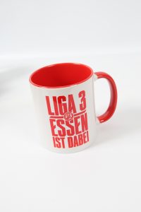 Weißer Kaffeebecher mit rotem Innenraum und dem Aufdruck 'LIGA 3 ESSEN IST DABEI'.