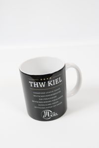 Schwarzer Kaffeebecher mit THW Kiel Logo und Meistertiteln aufgedruckt.