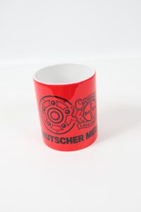 Roter Kaffeebecher mit dem Aufdruck 'Deutscher Meister' und dem Logo von Bayer 04 Leverkusen.