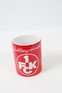 Roter Kaffeebecher mit dem Aufdruck 'Lieblingsverein' und dem Logo von 1. FCK.