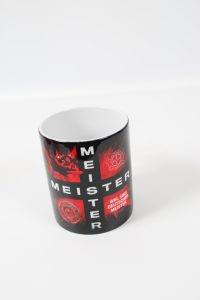Schwarze Tasse mit dem Aufdruck 'MEISTER' und verschiedenen Symbolen in roter Farbe.