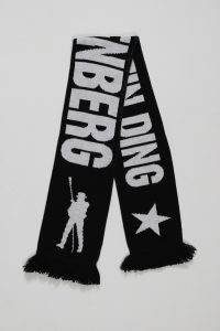 Schwarzer Strickschal mit dem Schriftzug 'WINDING' und einer stilisierten Figur auf einer Seite.