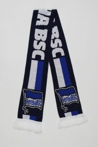 Blauer und weißer Strickschal mit dem Logo von Hertha BSC und Fransen am Ende.
