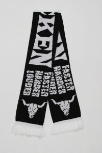 Schwarzer Jacquard-Schal mit weißen Schriftzügen und Fransen am Ende.