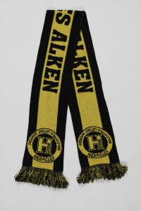 Ein gelber und schwarzer Schal mit dem Text 'Hercules Alken' und Fransen an den Enden.