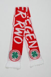 Rot-weißer Strickschal mit Fransen und einem Logo in der unteren Ecke.