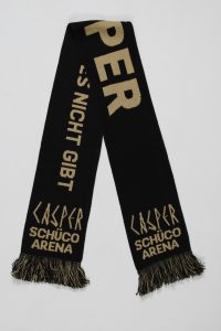 Schwarzer Schal mit goldenen Schriftzügen und Fransen, der den Namen 'CASPER' und 'SCHÜCO ARENA' zeigt.