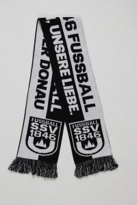 Schwarz-weißer Strickschal mit dem Text '16 FUSSBALL UNSERELIEBE' und dem Logo des SSV 1846 Donau.