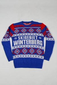 Blauer Pullover mit geometrischen Mustern und dem Schriftzug 'SKIGEBIET WINTERBERG'.