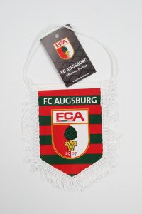 Wimpel des FC Augsburg mit Logo und Fransen in den Vereinsfarben.