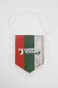 Wimpel der FCA Fußballschule mit rot-grünem Design und Fransen.