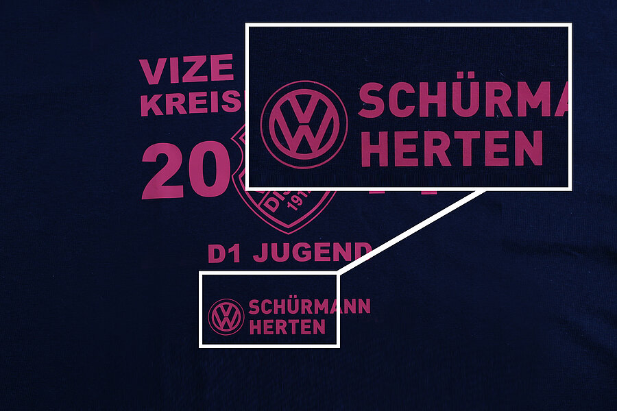 T-Shirt mit dem Schriftzug 'Schürmann Herten' und dem Volkswagen Logo in pink auf dunkelblauem Hintergrund.