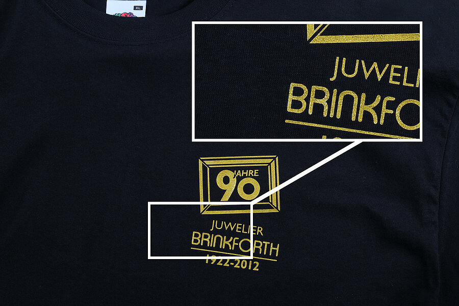 Schwarzes T-Shirt mit goldener Schrift und Logo von Juwelier Brinkforth, das 90 Jahre Jubiläum feiert.