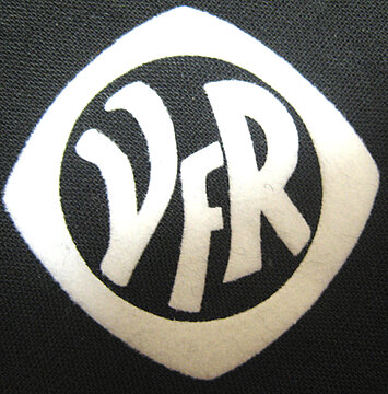 Logo von VFR in einem weißen, stilisierten Design auf schwarzem Hintergrund.