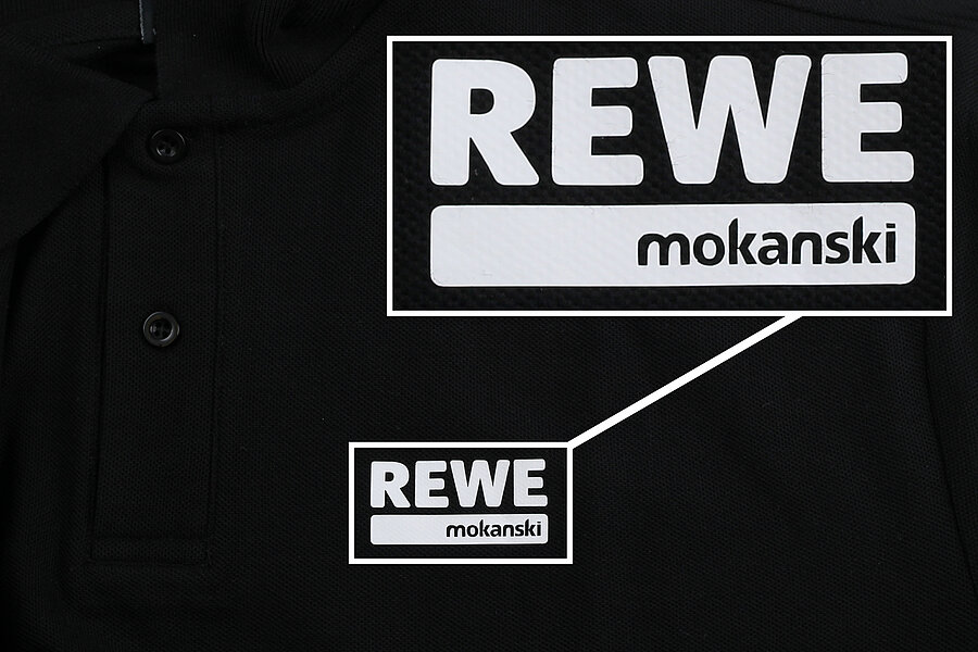 Schwarzes Poloshirt mit dem REWE-Logo und dem Namen mokanski auf der Brust.