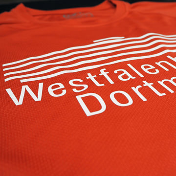 Rotes T-Shirt mit dem Schriftzug 'Westfalen Dortmund' in weißer Schrift auf der Vorderseite.