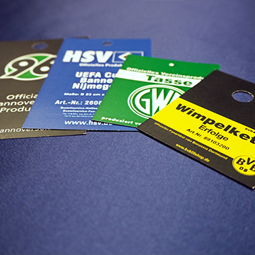 Vier Hangtags in verschiedenen Farben, die für Sportartikel verwendet werden, mit unterschiedlichen Logos und Texten.