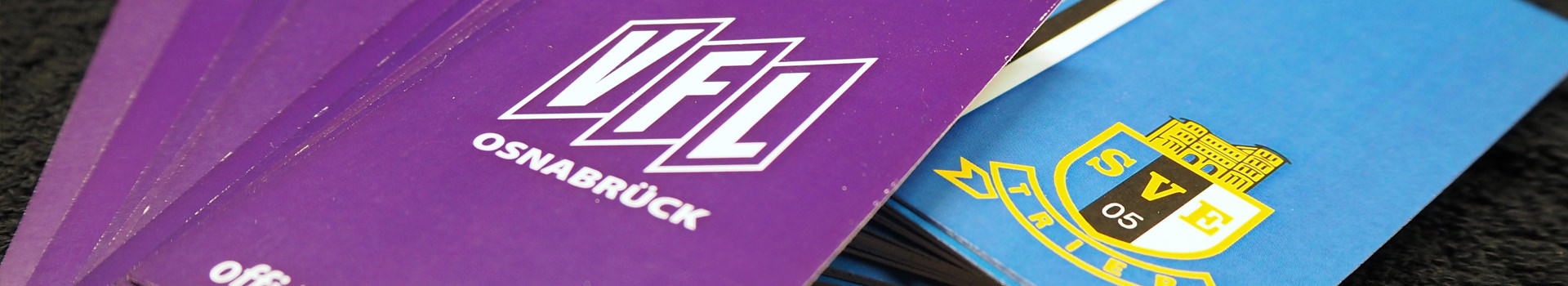 Hangtags in lila und blau mit den Logos von VfL Osnabrück und SV Eintracht Osnabrück.