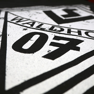 Logo von Waldhof 07 in Schwarz-Weiß auf einem Textil mit geometrischem Design.