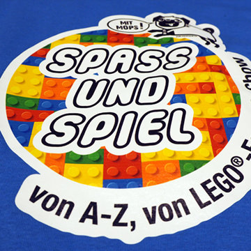 Bunte LEGO-Platten mit dem Text 'Spass und Spiel von A-Z, von LEGO' auf einem blauen Hintergrund.