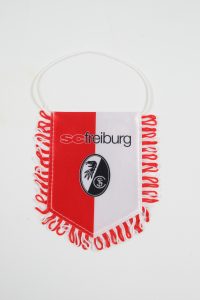 Wimpel des SC Freiburg in Rot und Weiß mit dem Vereinslogo und Fransen.