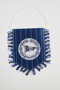 Stoffwimpel in Blau mit einem weißen A-Logo und Fransen in Schwarz und Blau.