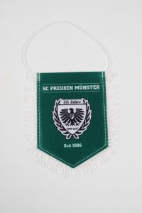 Wimpel des SC Preußen Münster mit dem Logo und der Aufschrift '111 Jahre seit 1906'.