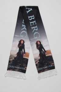 Schal mit einer abenteuerlichen Figur und dem Text 'ABENTEUER' in deutscher Sprache.