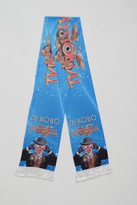 Blauer Schal mit dem Schriftzug 'DJ Bobo Mystorial' und grafischen Elementen in bunten Farben.