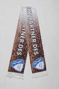 Schal mit dem Text 'Partner des' und einem Logo auf einer Kaffeebohnen-Hintergrundgrafik.