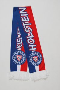 Schal des Kieler SV Holstein in Rot und Blau mit Fransen und Vereinslogo.