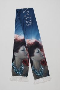 Schal mit einem Meerjungfrau-Motiv und dem Schriftzug 'Atlantis' in blauer Farbe.