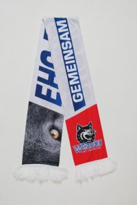 Fan-Schal des EHC Freiburg mit einem Wolf-Motiv und dem Schriftzug 'Gemeinsam'.