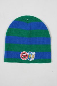 Gestreifte Mütze in Grün und Blau mit zwei Aufnähern, einem roten und einem blauen.