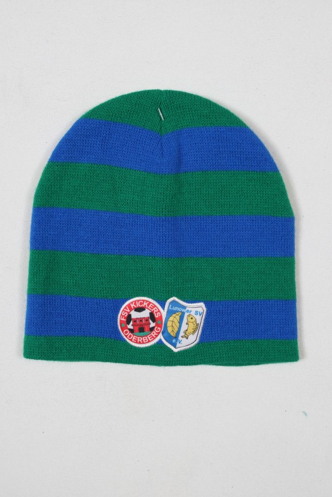 Gestreifte Mütze in Grün und Blau mit zwei Aufnähern, einem roten und einem blauen.