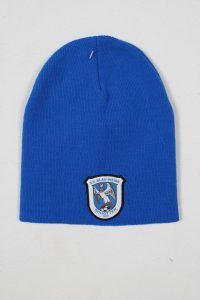 Blaue Strickmütze mit einem runden Logo des S.V. Blau-Weiß Schottel auf der Vorderseite.