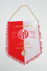 Wimpel des 1. FSV Mainz 05 mit Vereinsfarben und Aufschrift für ein Fußballspiel.