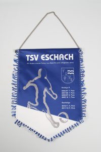 Blauer Wimpel des TSV Eschach mit einem Fußballspieler und Platzierungen aufgedruckt.