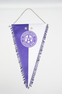 Dreieckige Fahne des Fußballklubs Austria Wien mit Logo und Fransen in lila und weiß.