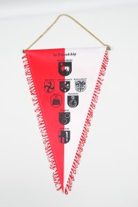 Ligawimpel in Rot und Weiß mit verschiedenen Vereinswappen und einer goldenen Kette zur Aufhängung.