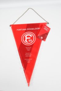 Roter Wimpel von Fortuna Düsseldorf mit Vereinslogo und Meistertiteln aufgedruckt.